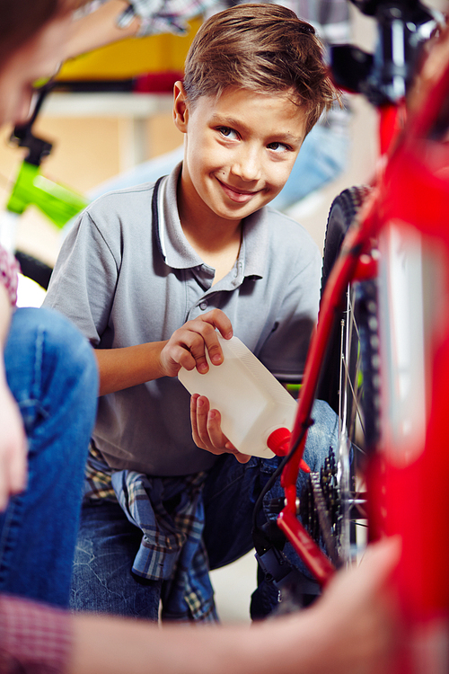 Little boy repairing his bicycle