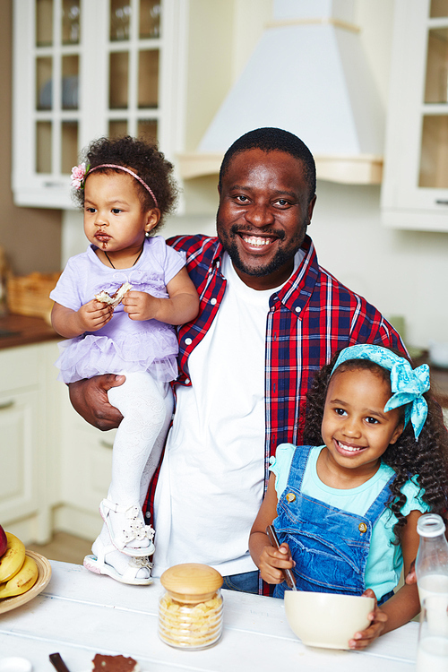 Family of father and two daughters in the kitchen