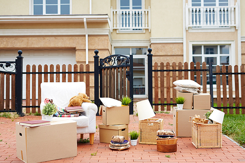 Packed things in front of wooden fence and new house