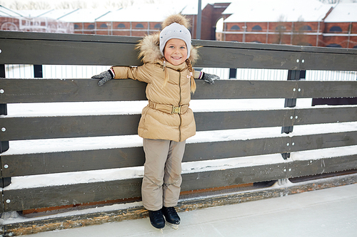 Young girl on skates spending time on ice-rink