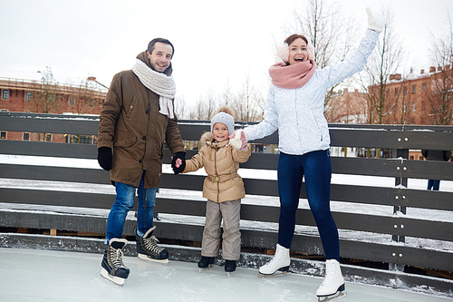 Family of father, mother and daughter on skating rink