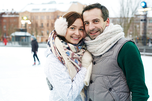 Urban couple in winterwear embracing outdoors