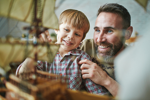 Father showing a ship model to his son