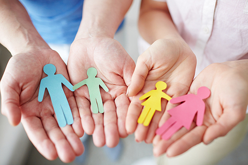 Close-up of hands holding paper family cutout