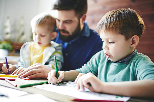 Young man and his sons drawing with highlighters