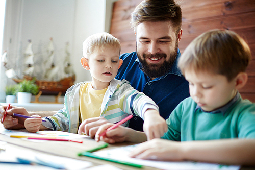 Little boy pointing at his brother drawing