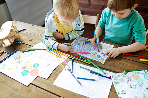 Adorable siblings coloring pictures with highlighters