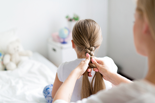 Female plaiting her daughter long hair