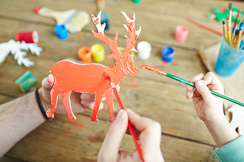 Wooden deer figure being painted by gouache