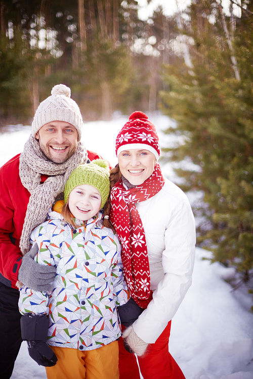 Happy family spending leisure in winter forest