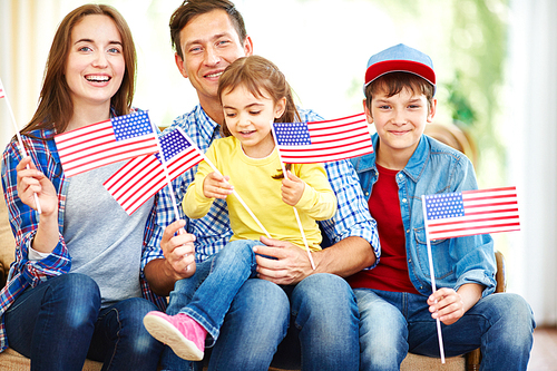 Happy family with flags of USA celebrating Independence Day