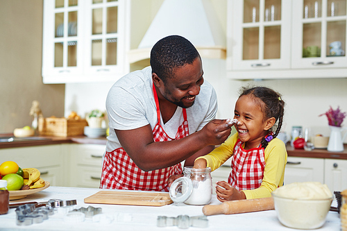 Happy family of two cooking together at home