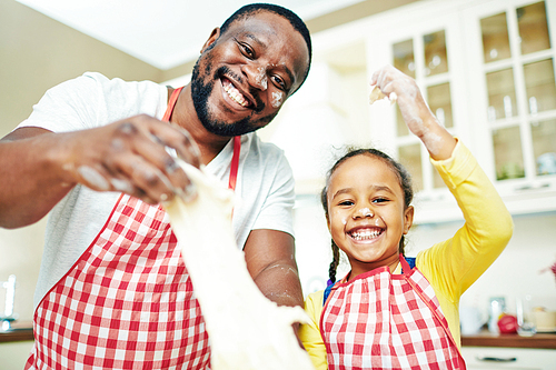 Happy man with dough and his daughter looknig at camera