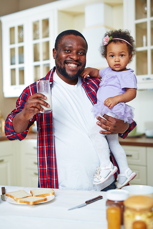 Happy father with his baby drinking milk at home