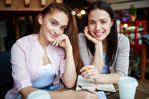 Teenage groupmates doing homework in cafe