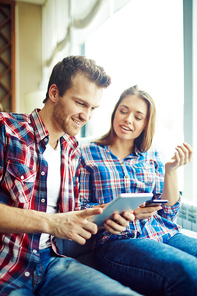 Young couple spending time together and using gadgets