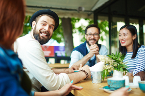 Happy man looking at girl during talk in cafe