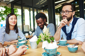 Young people drinking coffee at coffeeshop outdoors