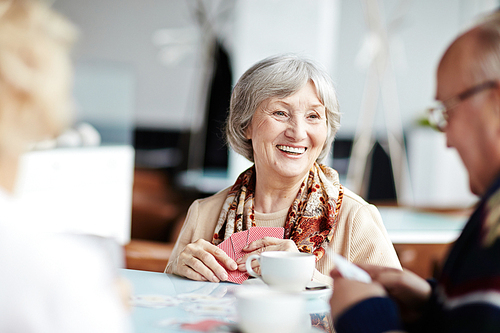 Senior people playing cards in cafe