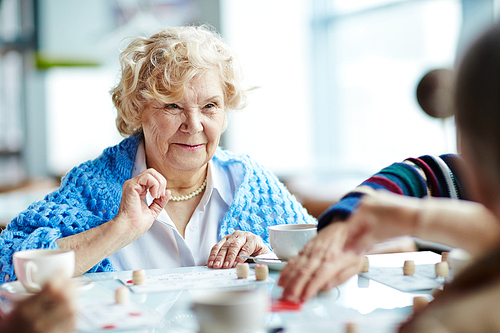 Senior woman playing lotto with friends