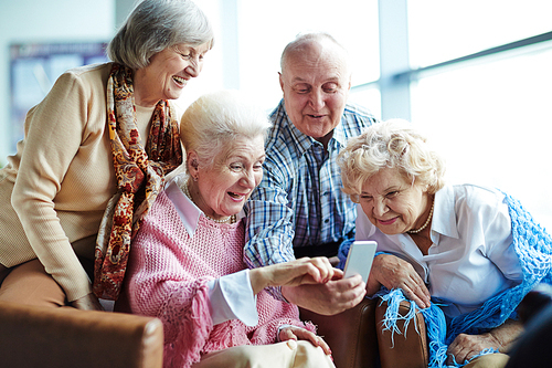 Group of seniors using mobile phone