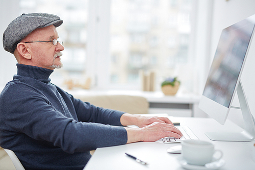 Mature man computing in front of monitor