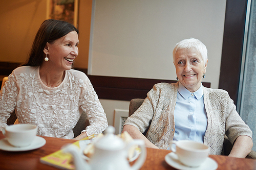 Two senior females spending evening in cafe