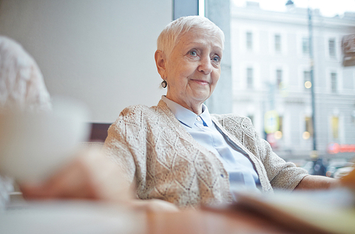 Pretty senior female in casualwear relaxing in cafe