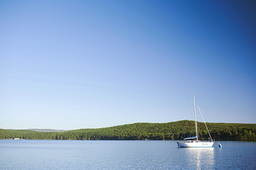 Luxurious yacht floating in river on hot summer day