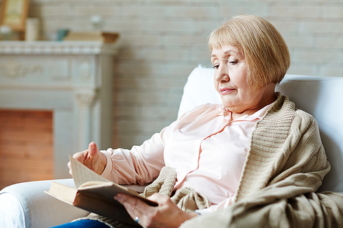 Senior female reading in arm-chair