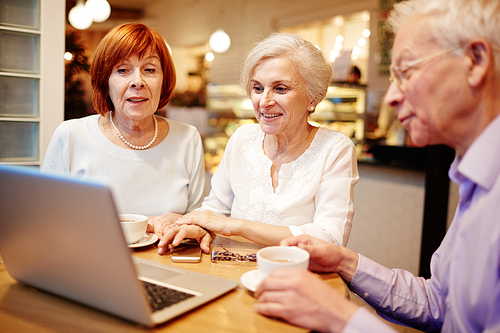 Group of old buddies watching something interesting in laptop