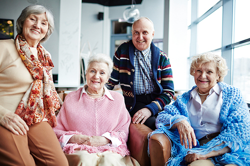 Group of friendly seniors relaxing in cafe