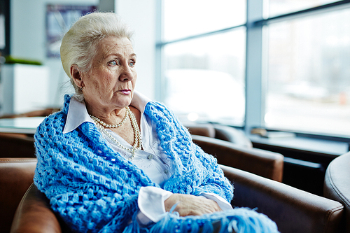 Senior female sitting in arm-chair