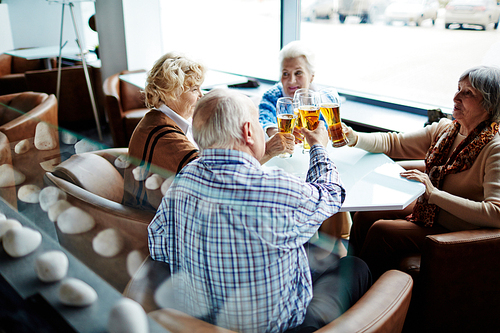 Group of restful seniors having beer in cafe
