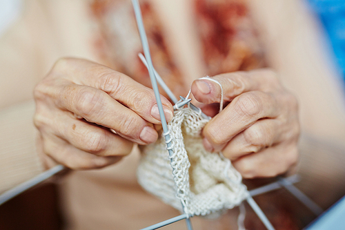 Hands of elderly woman knitting sock