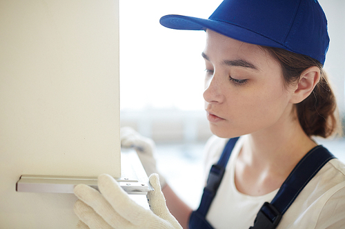 Young worker measuring corner with special tool