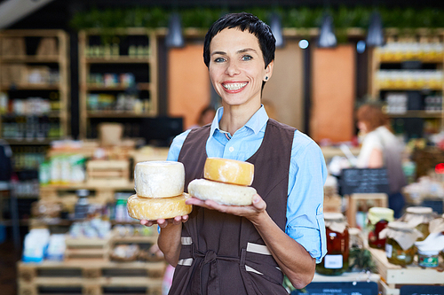 Seller of dairy products holding cheese