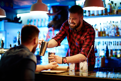 Happy barman making drink for client