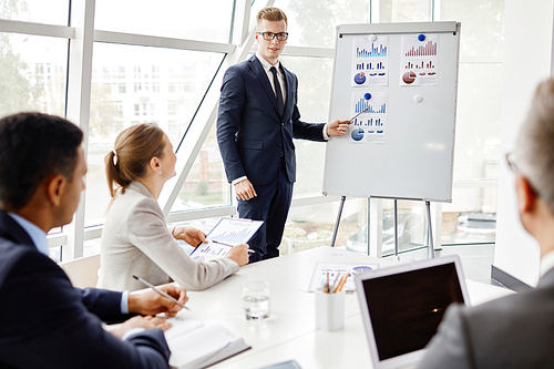 Young businessman presenting business project to his colleagues