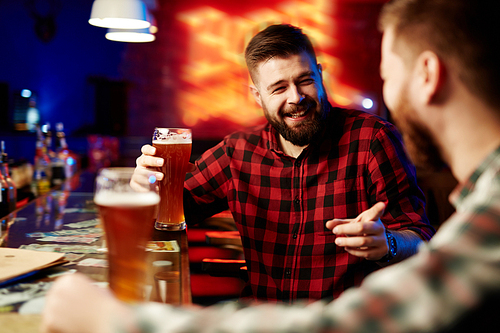 Man drinking beer and laughing with his friend