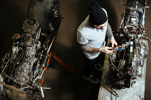 Professional technician repairing custom-bikes in garage