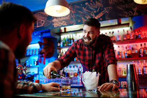 Young bearded barman working in pub