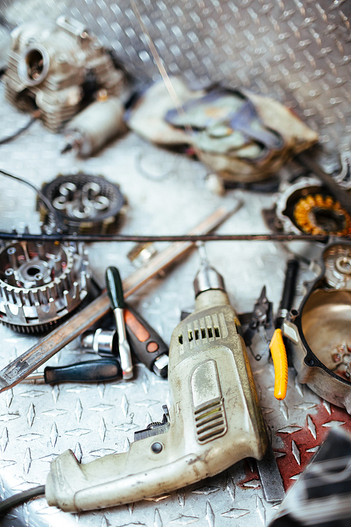 Electric drill and spare-parts on workplace of repairman