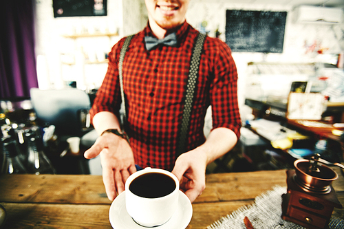 Male barista serving hot coffee