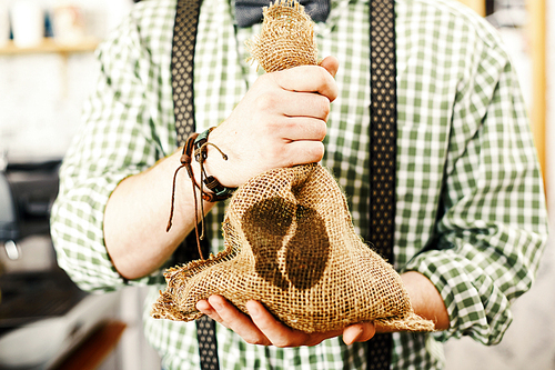 Barista holding sack with coffee grains