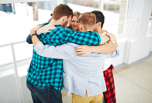 Group of students embracing while standing in circle