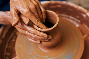 Hands of master making clay pottery