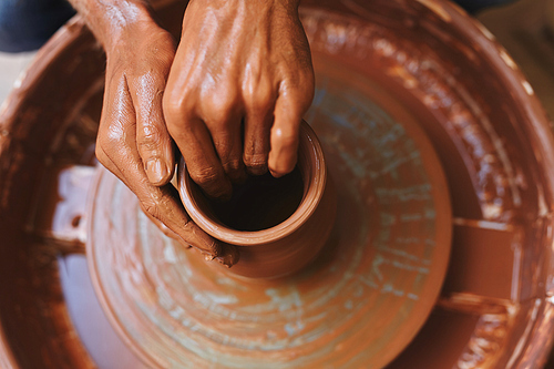 Hands of potter during work on wheel