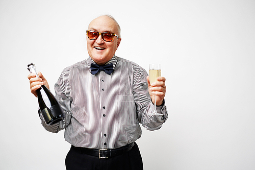 Elegant pensioner holding bottle and flute with champagne