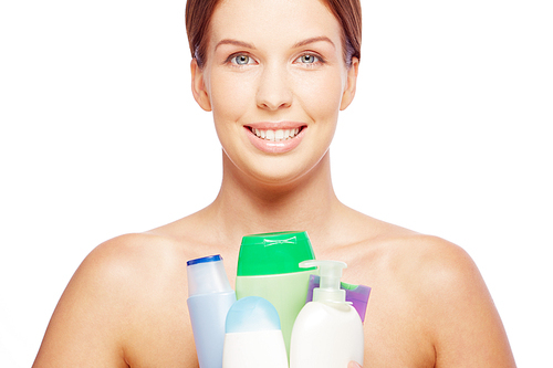 Smiling healthy woman holding lotion containers